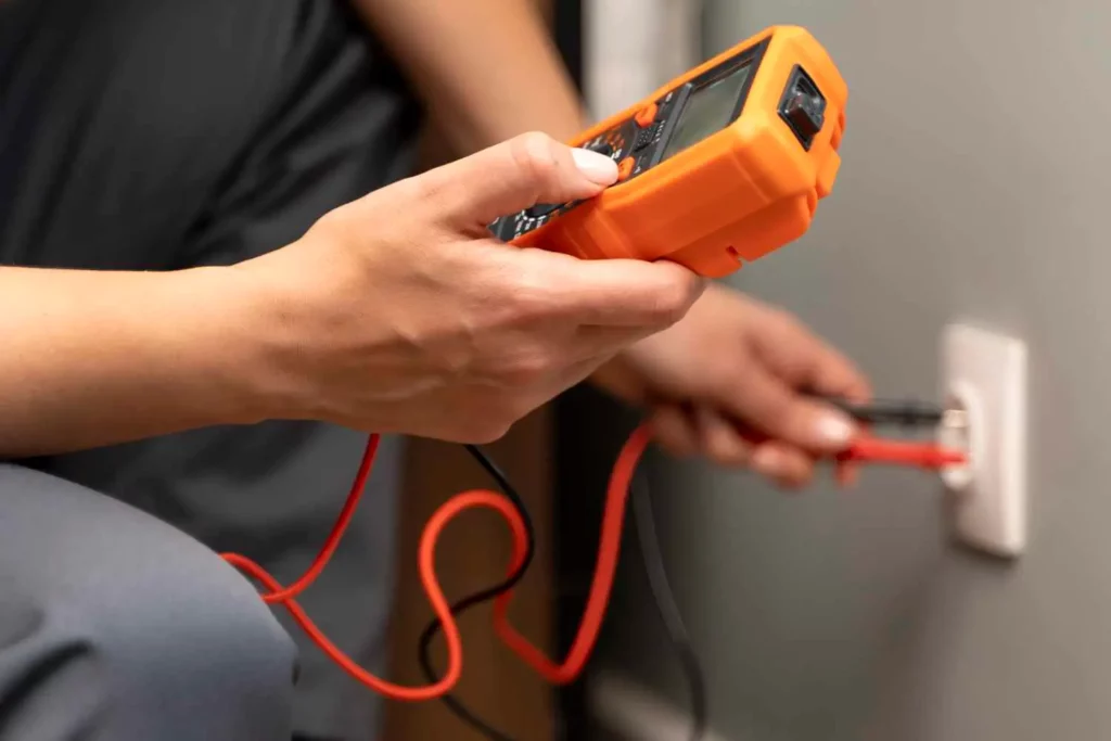 technician using electrical meter equipment to check outlet