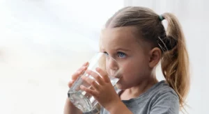 Small child drinking from a glass of water